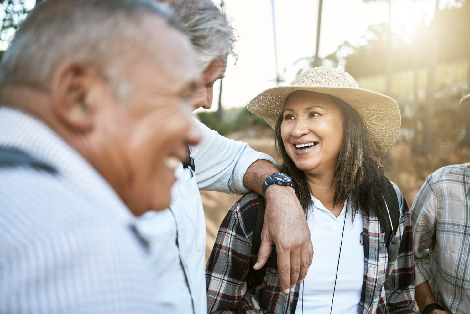 A woman smiles warmly while hiking with a group of friends in casual attire, under sunlight with a natural background in apache junction az